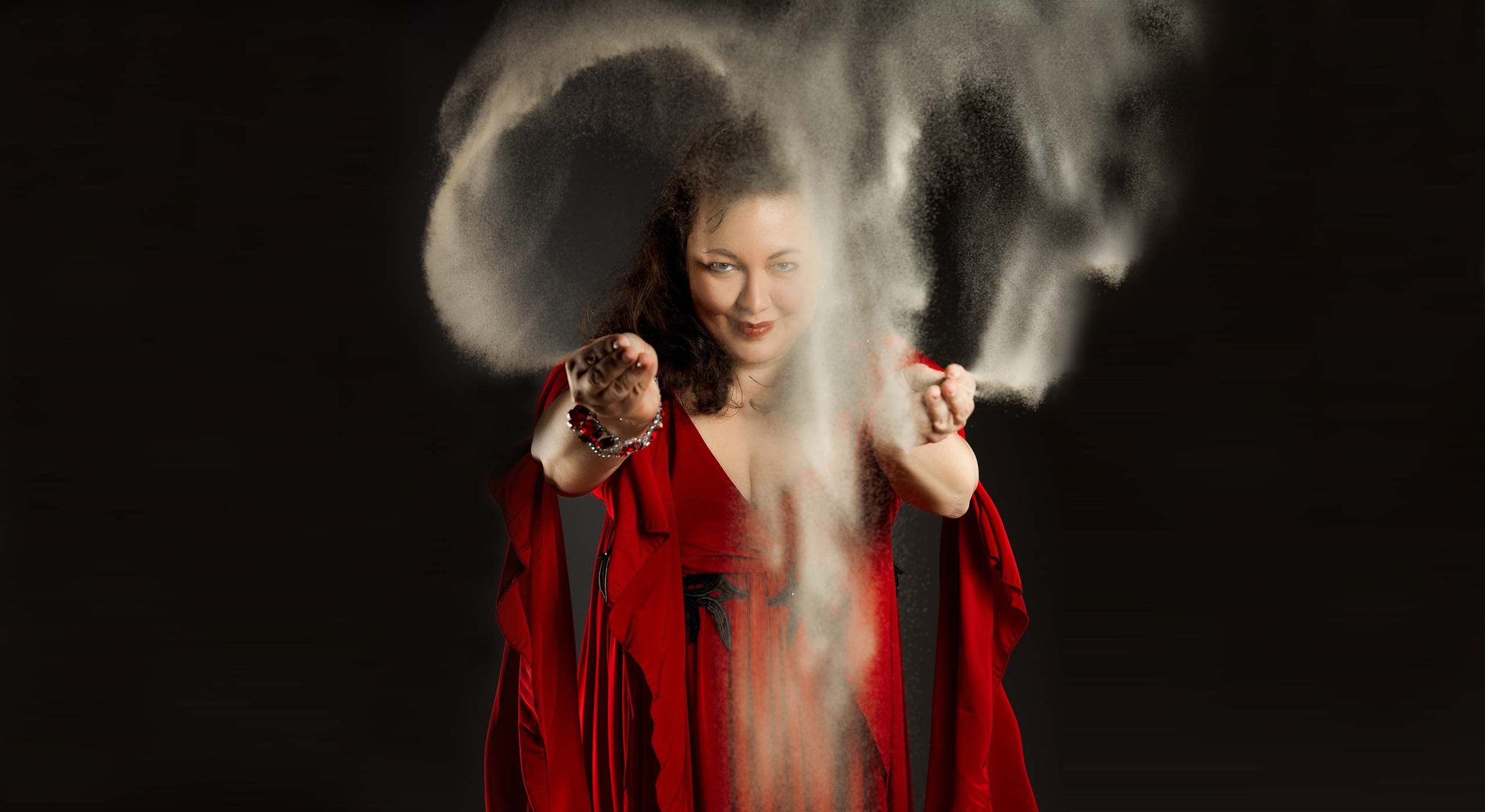 Elena Handel im roten Kleid bei einer Live-Sandshow an der Leuchtplatte