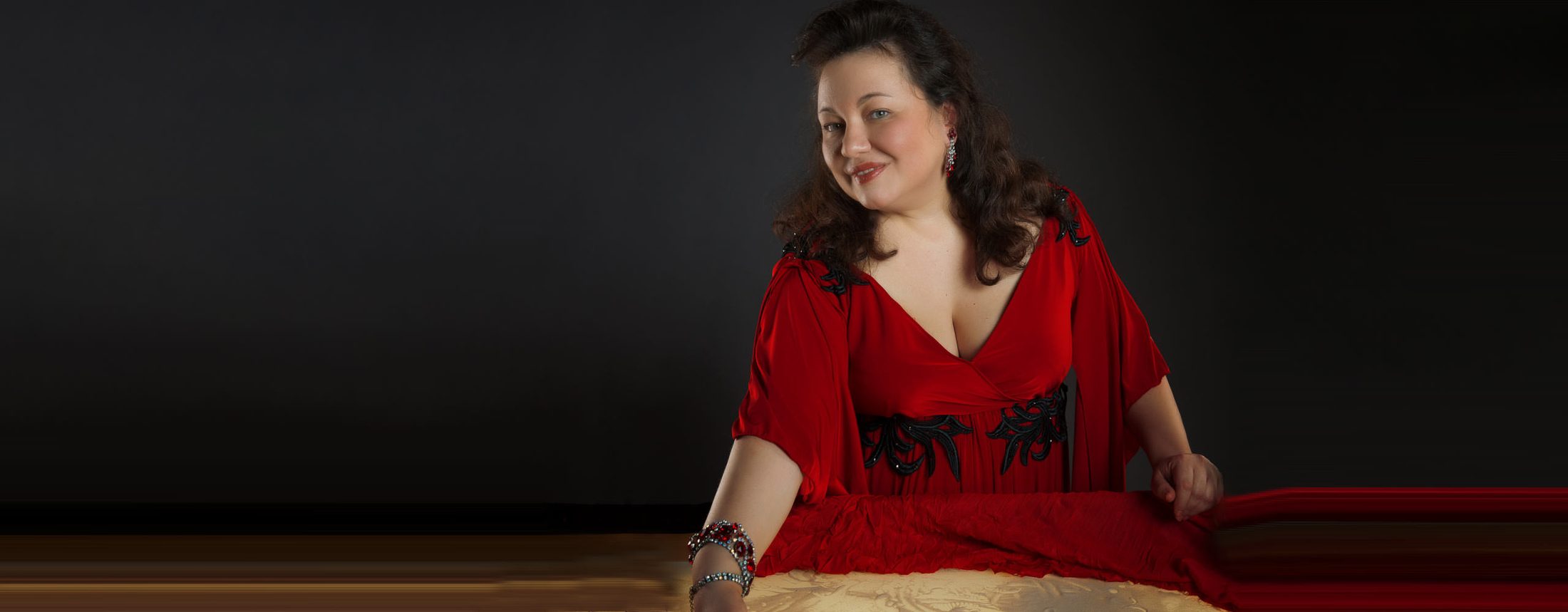 Elena Handel im roten Kleid an ihrem Sandtisch